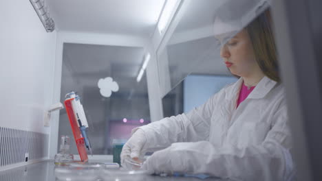 una mujer con una bata de laboratorio trabaja en un laboratorio