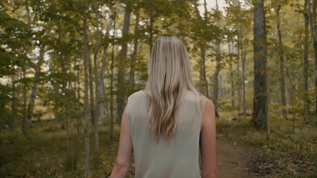 Woman Walking on a Forest Path in Autumn