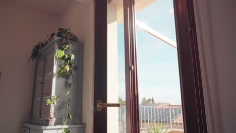 joven abre la puerta de la terraza