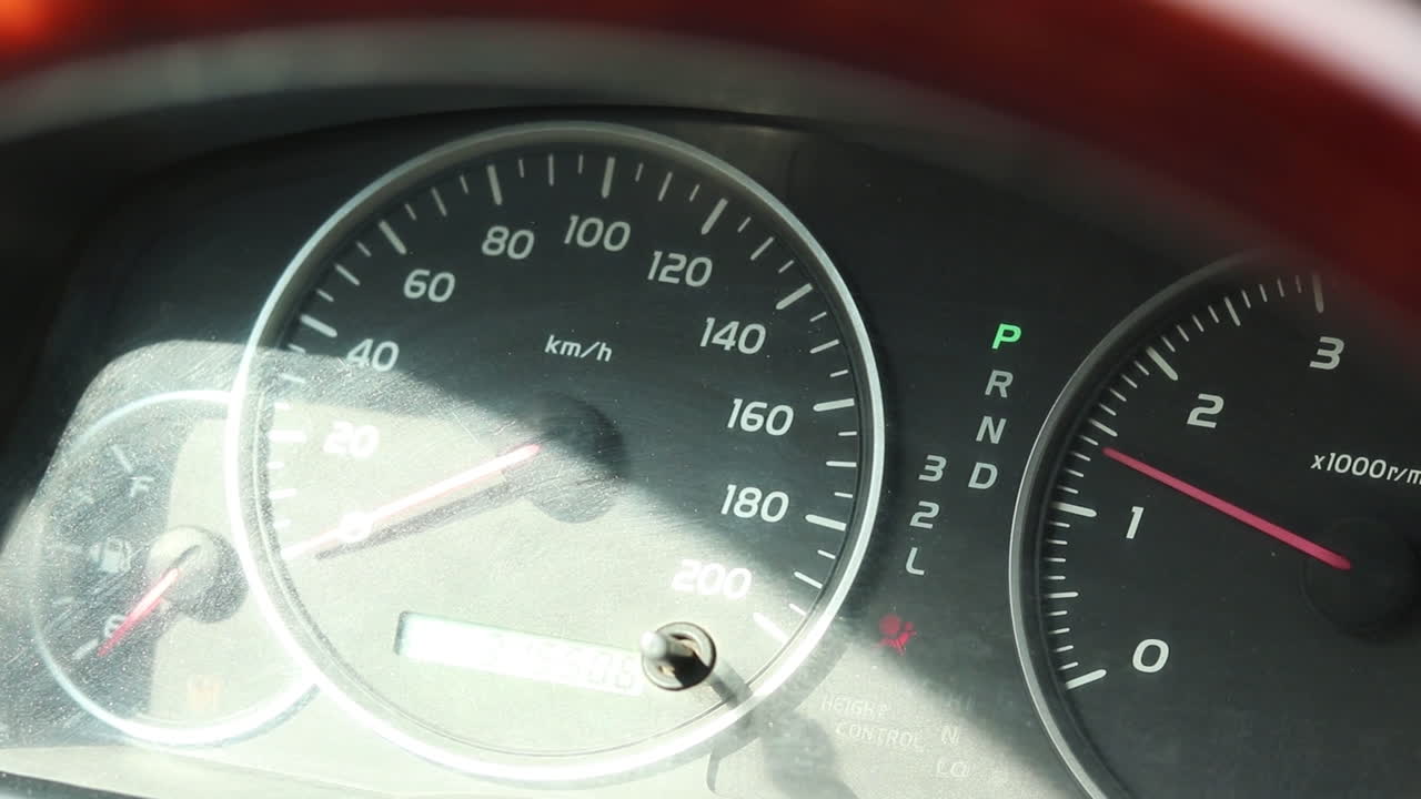 Closer up of a car dashboard with instruments like a speedometer, tachometer and burning lights. The engine revs and the pointer of the tachometer goes up. Mechanic testing the car after fixing engine