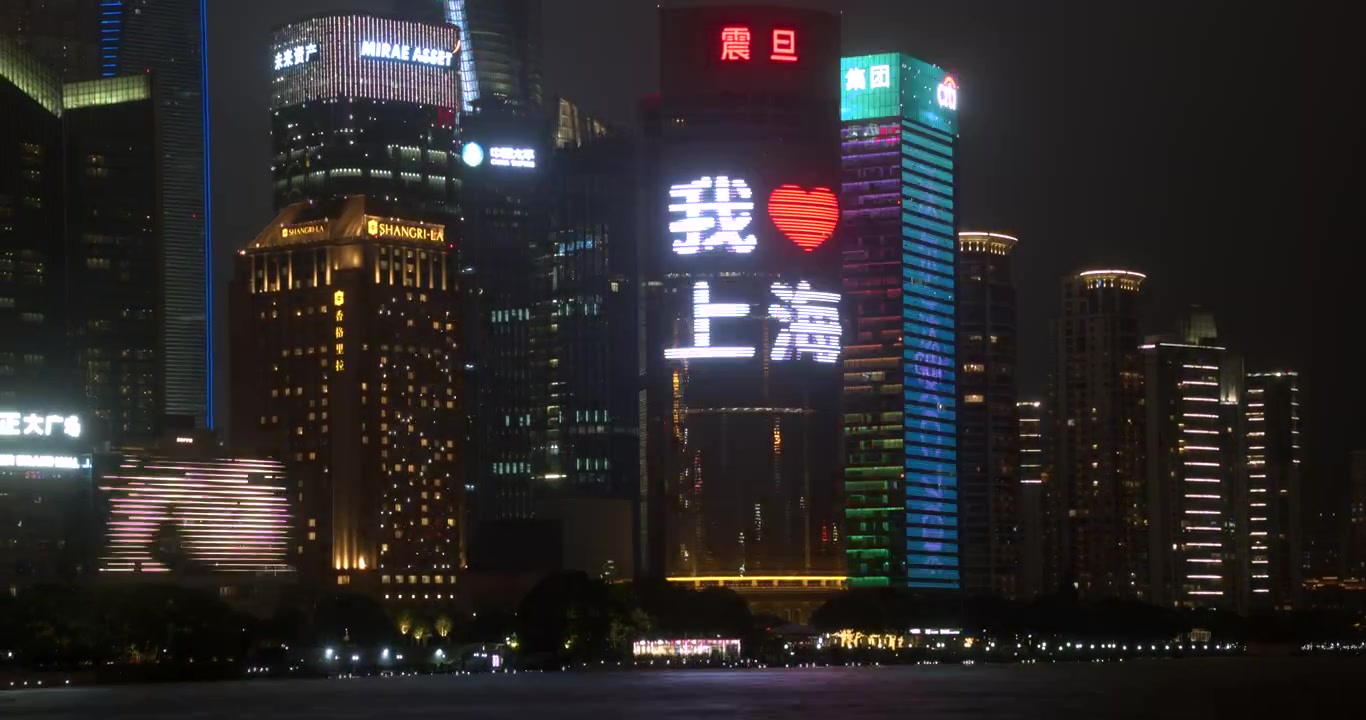 Arranha-céus iluminados em Xangai à noite com projeções do Dia da Terra