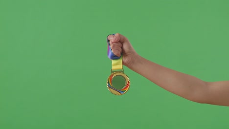 medalla de oro en la mano. fondo de pantalla verde