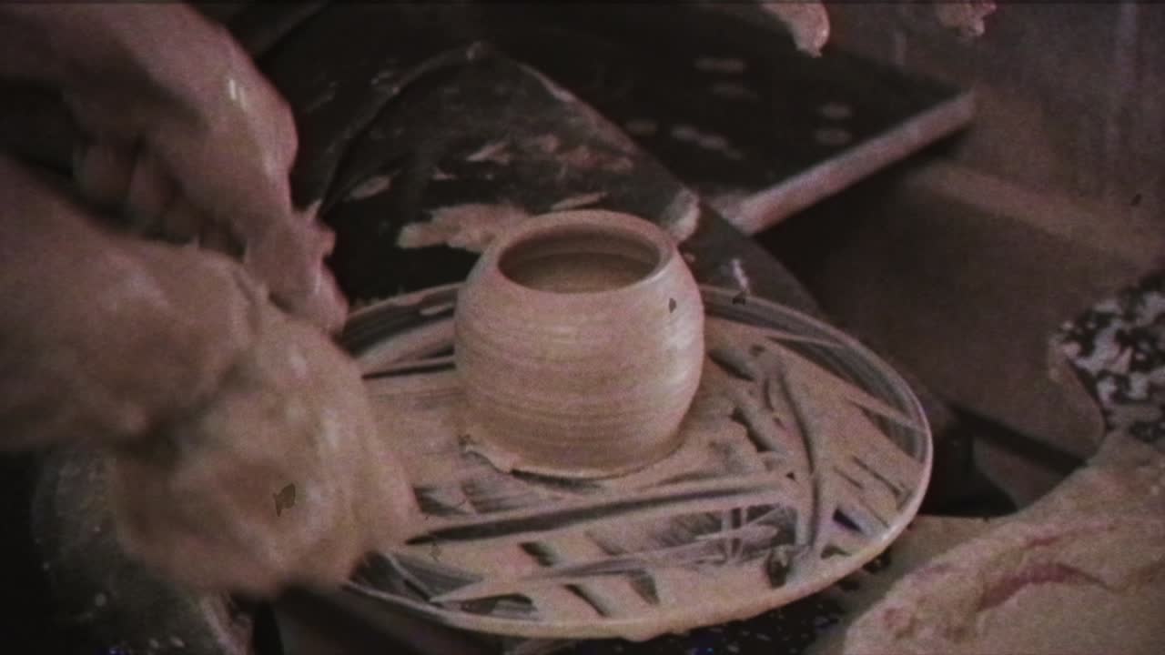 Un vasaio insegna a una donna a creare piatti di argilla. Un uomo prende le mani di una donna. Effetto vintage