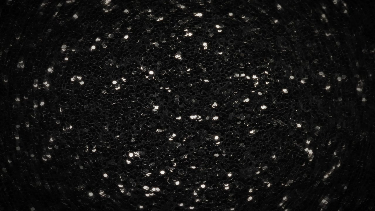 Glitter argentato che sfuma nel nero. Sfondo astratto.