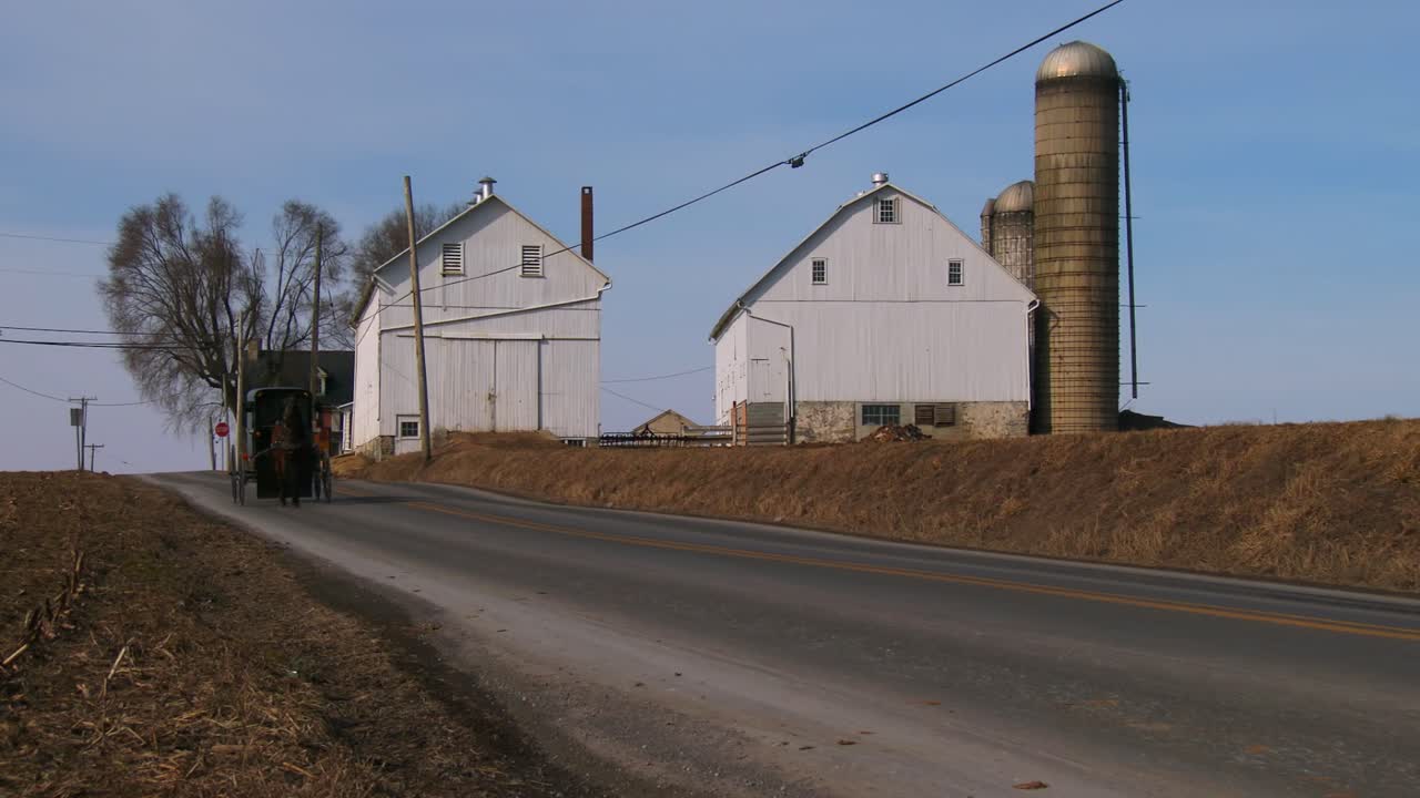 un carro de caballos amish viaja a lo largo de una carretera en la zona rural de pennsylvania 2