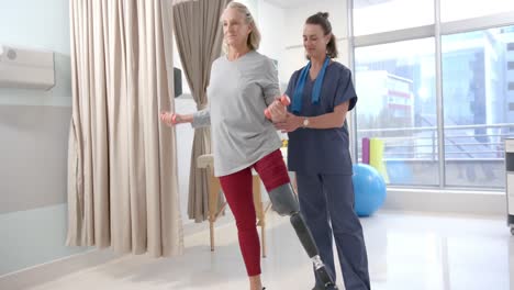 Fisioterapeuta-Femenina-Caucásica-Y-Paciente-Senior-Con-Prótesis-De-Pierna-Haciendo-Ejercicio