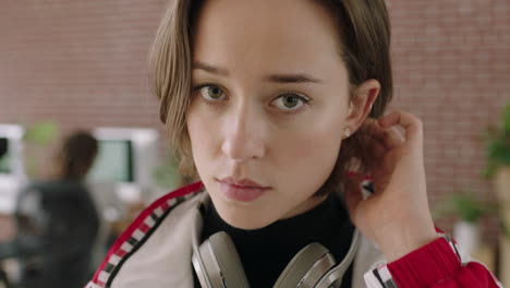 close up portrait of stylish young caucasian woman looking serious pensive at camera running hand through hair in contemporary internet cafe workspace