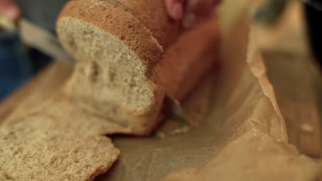 extreme close up of female hands slicing loaf of bread