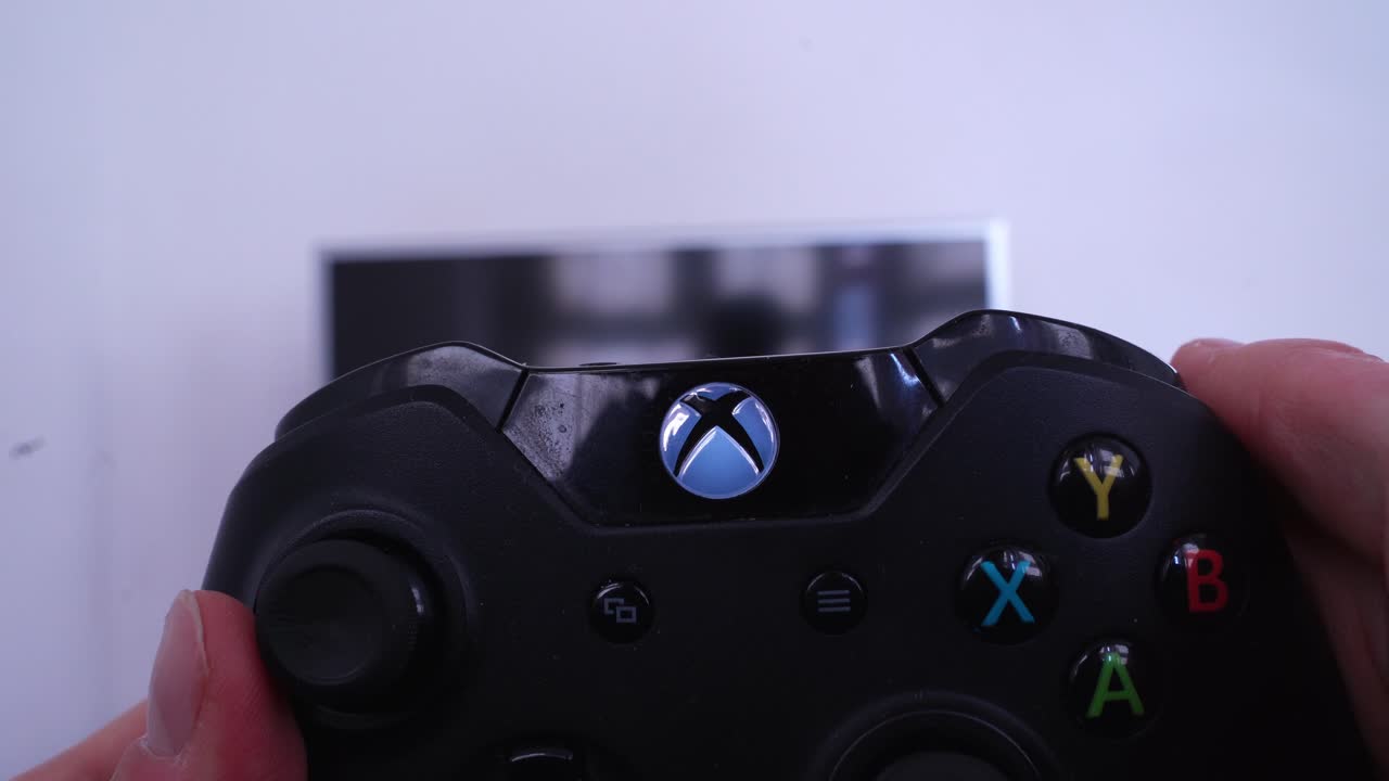 Turning Xbox One videogame on with controller, close up