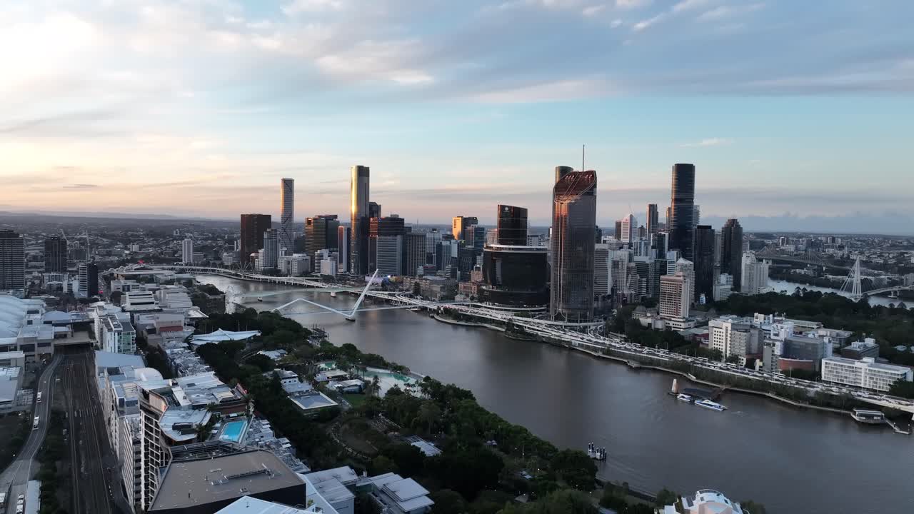 Langsom drone-sidetracking ved den gyldne time, med Emporium Hotels tagterrasse i forgrunden og Brisbane-floden, Queens Wharf og CBD's skyline i baggrunden, Brisbane, QLD, Australien