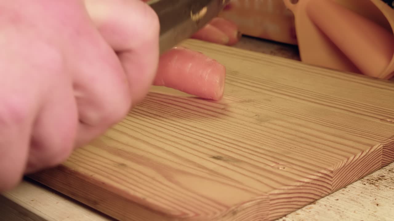 Low angle close up: Chopping raw carrots on wooden cutting board