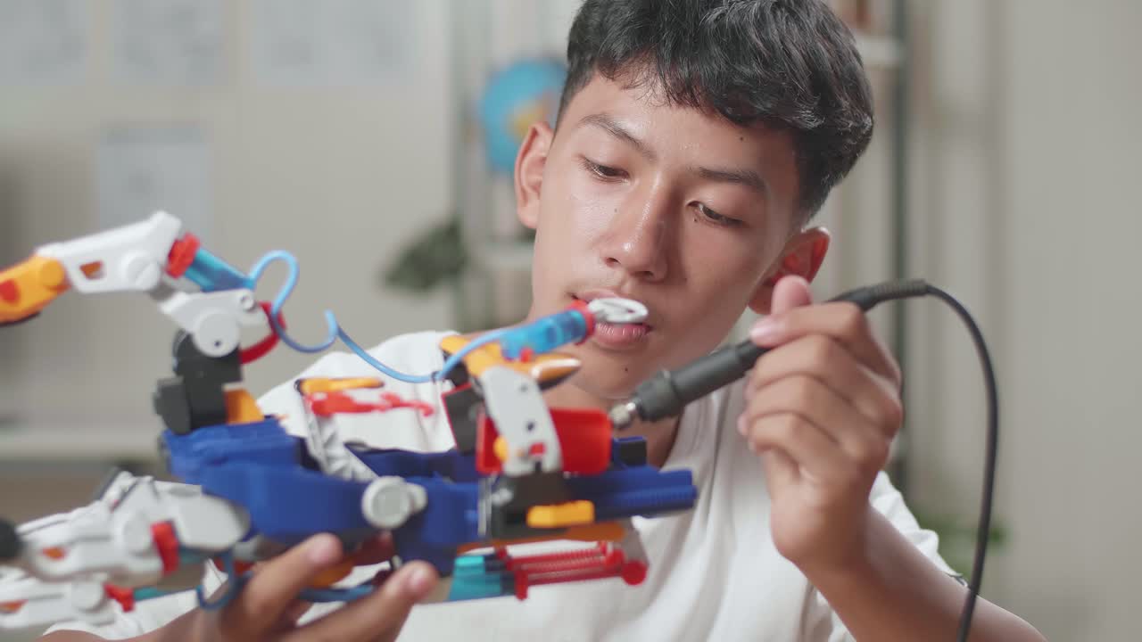 un niño asiático reparando una mano de cyborg en casa.