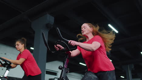 Grupo-De-Chicas-Atléticas-Realizando-Ejercicios-De-Entrenamiento-Aeróbico-En-Bicicleta-Estática-En-El-Gimnasio