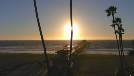 sunset at the beach pier with palm trees
