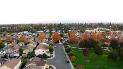 aerial view of a suburban neighborhood with autumn foliage and park