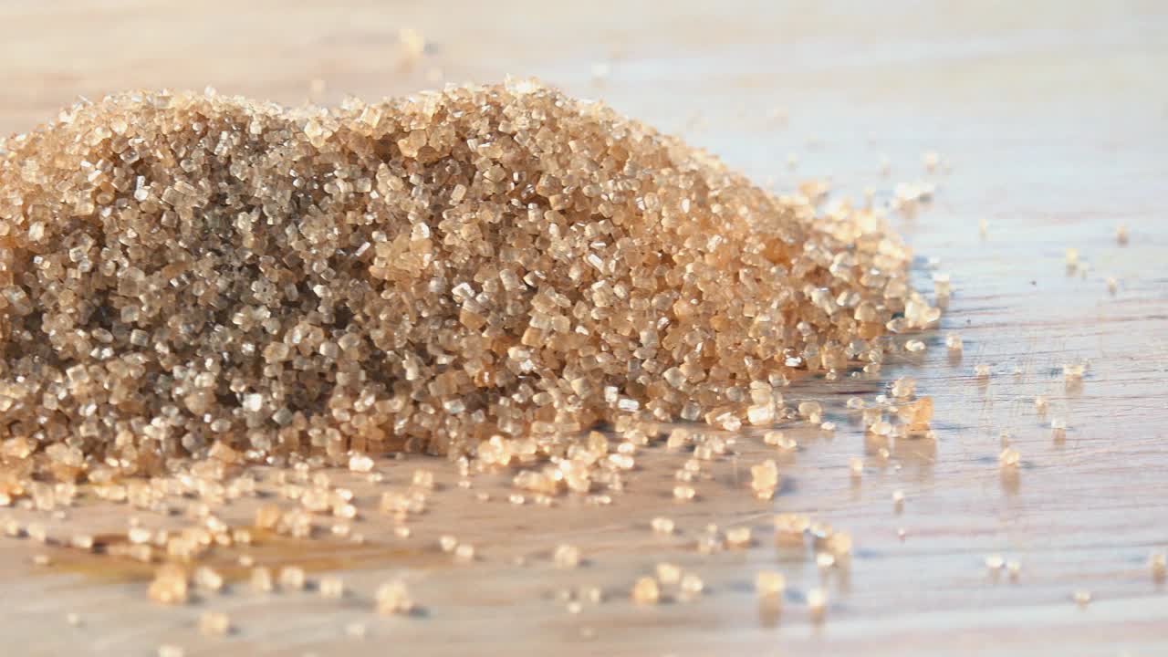 Brown Sugar Granules Rotating on a Wooden Board