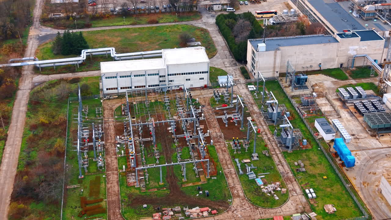Luftfoto af transformerstation og industriel infrastruktur. Detaljeret ovenfra-optagelse af højspændingstransformere og el-ledninger på et industriområde.