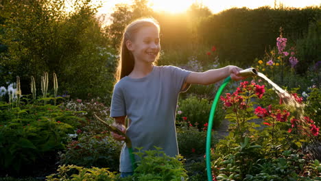 young girl watering plants in a garden at sunset