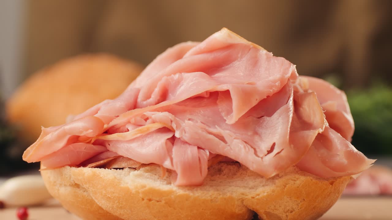 Mortadella ham sandwich, Traditional italian focaccia filled with thin pesto slices of mortadella, served by chef man in cafe restaurant. Macro of traditional italian spanish tapas antipasti.