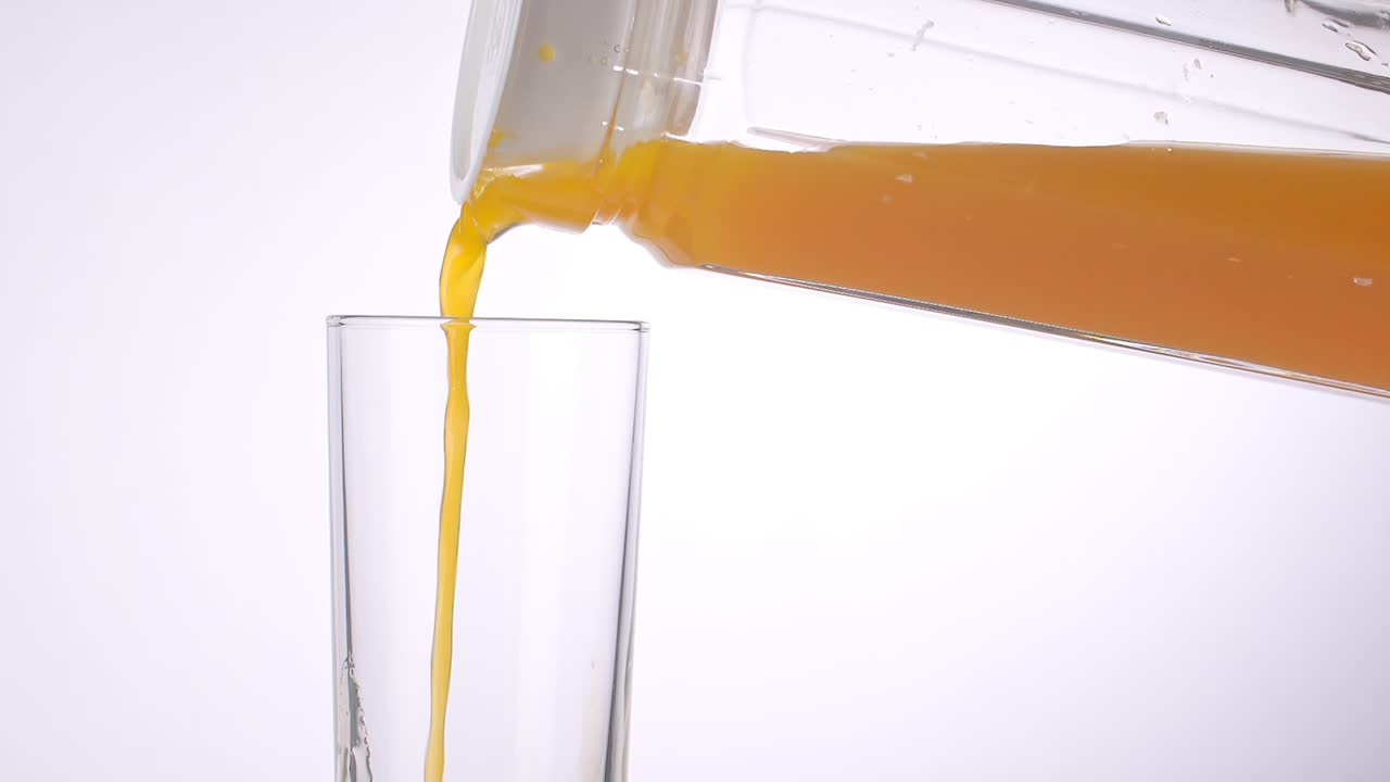 Versare il succo d'arancia in un bicchiere