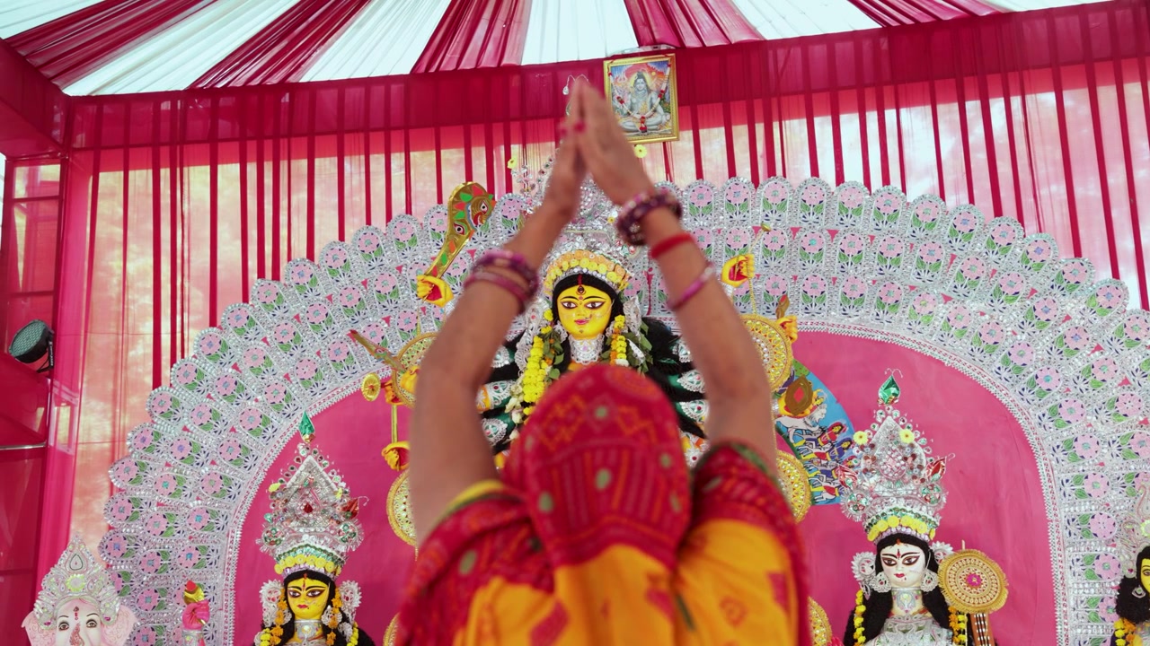 Sagrado Ídolo da Deusa Durga através da mão orante do devoto em uma perspectiva única.