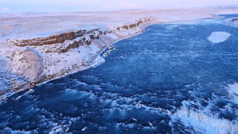 aerial view of frozen gulfoss waterfall in iceland with wild river