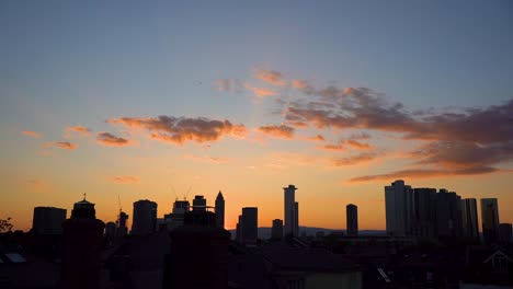 sunset over silhouetted frankfurt skyline with vibrant clouds