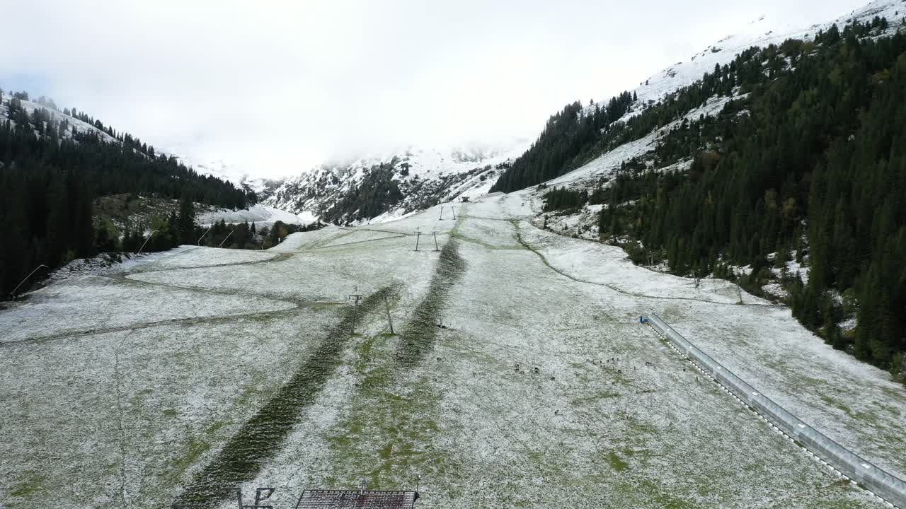 Pascolo alpino innevato nella Zillertal con infrastrutture sciistiche e alberi sparsi.