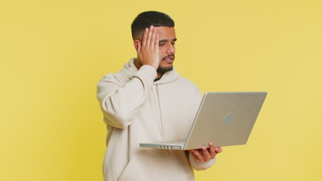 Displeased indian man use laptop surprised by bad news fortune loss game fail lottery results
