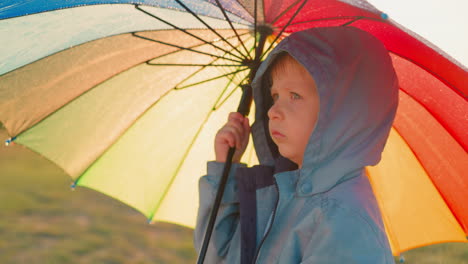 boy holds umbrella as rainfall persists thoughtful child finds in uncomfortable place with emotions