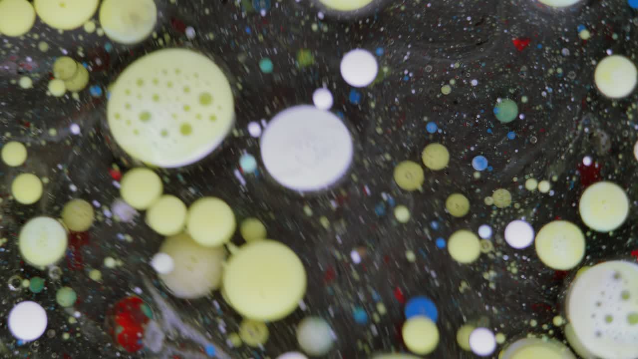 burbujas coloridas. mezcla abstracta de amarillo y azul sobre un fondo negro. fondo de pintura de color artístico.