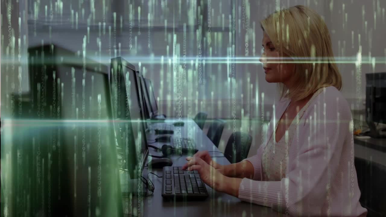 Woman leaning and typing in computer lab, initiating tech demo with green code overlay and smiling