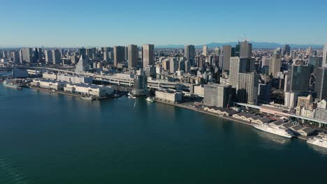 aerial view of cityscape of tokyo at sunrise, waters of tokyo bay and skyscrapers skyline of modern japanese capital city, clear blue sky - landscape panorama of japan from above, asia