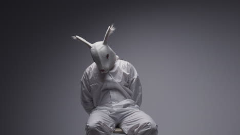 person wearing a rabbit mask and tied up in a studio