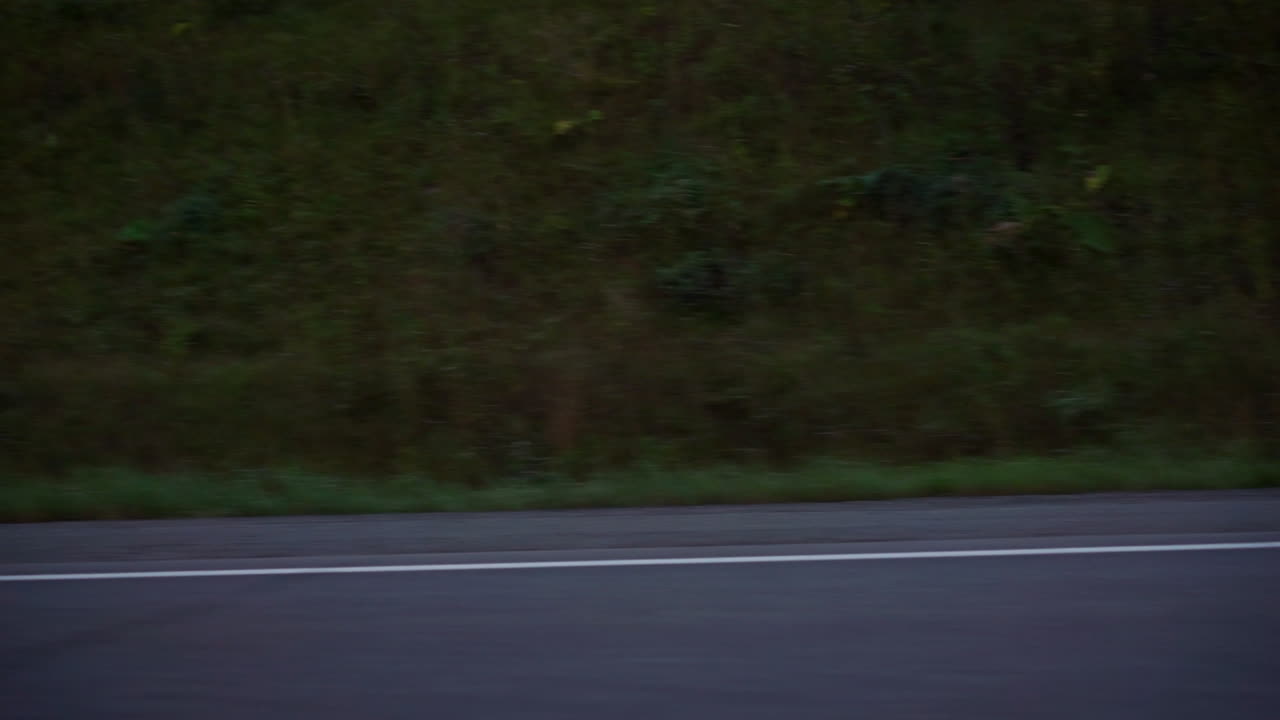 황혼과 새벽에 도로에서 운전하는 은색 자동차