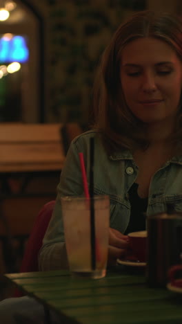 woman enjoying drinks at a cafe at night