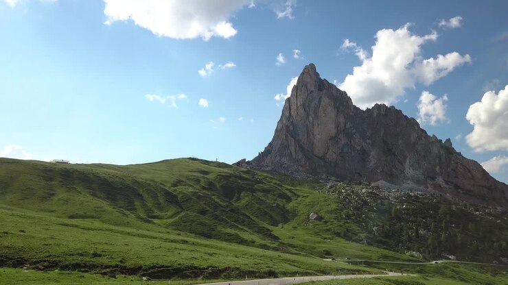 Wunderschöne Landschaft, grüne Felder und hohe Berggipfel am Passo di Giau, Dolomiten, Italien.