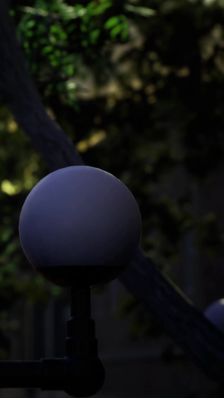 Light source stands in a dark garden with trees at night in a quiet area