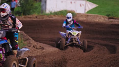 quad racing competition - racers on dirt muddy passing extreme turn in slow motion