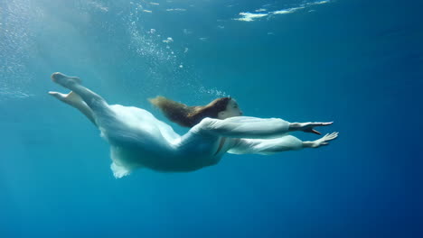 woman in white dress floating underwater