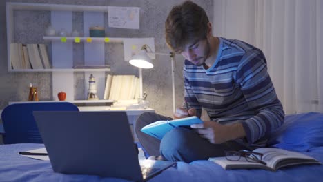 joven estudiante haciendo investigación en la cama por la noche pensativo.