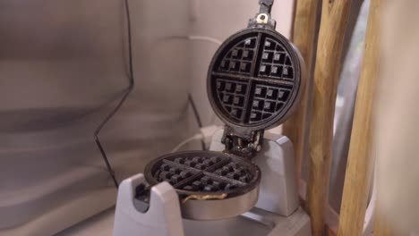 crop woman spreading oil on waffle iron in kitchen