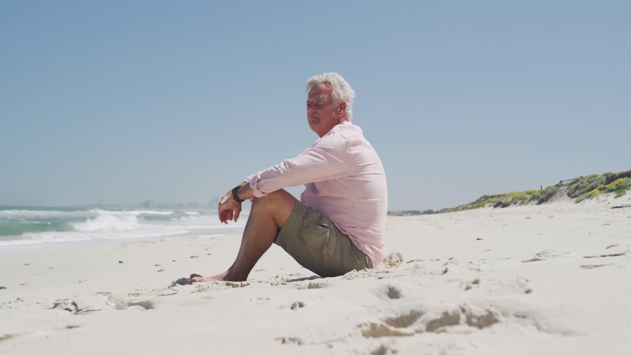 Senior caucasian man sitting on the beach enjoying the view