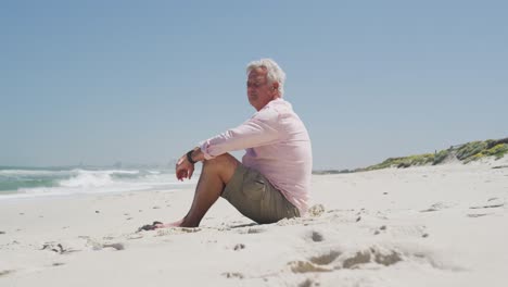 Hombre-Caucásico-Mayor-Sentado-En-La-Playa-Disfrutando-De-La-Vista