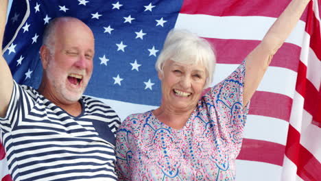 senior couple holding american flag