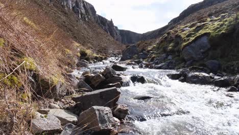 Scenic-landscape-view-of-the-idyllic-Allt-Chranaidh-river-flowing-through-rugged-and-rocky-mountainous-terrain-in-wilderness-of-the-highlands-of-Scotland-UK