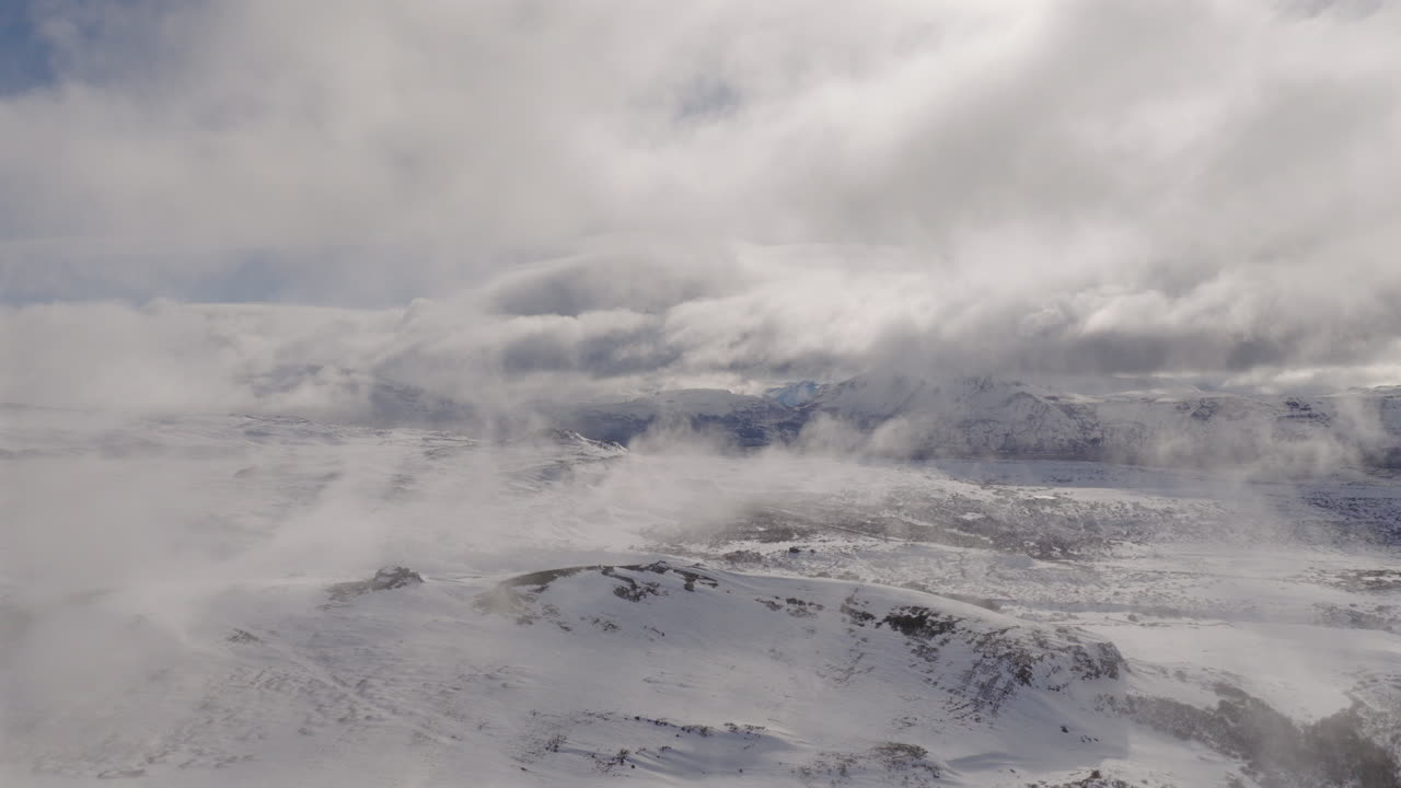 Aerial view of snow-covered Caviahue-Copahue in Neuquén, Argentina, with clouds floating overhead