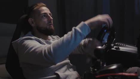 man playing racing video game at night