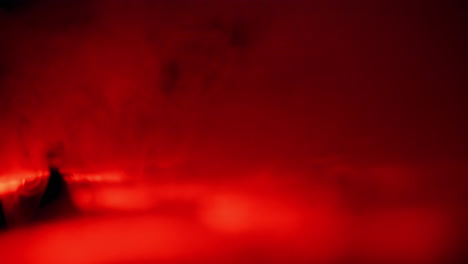 abstracte rode lasers die rook verlichten in een pitch zwarte kamer