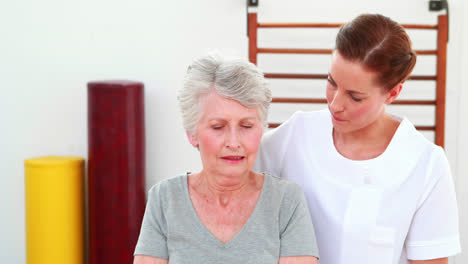 Physical-therapist-helping-patient-lift-hand-weights